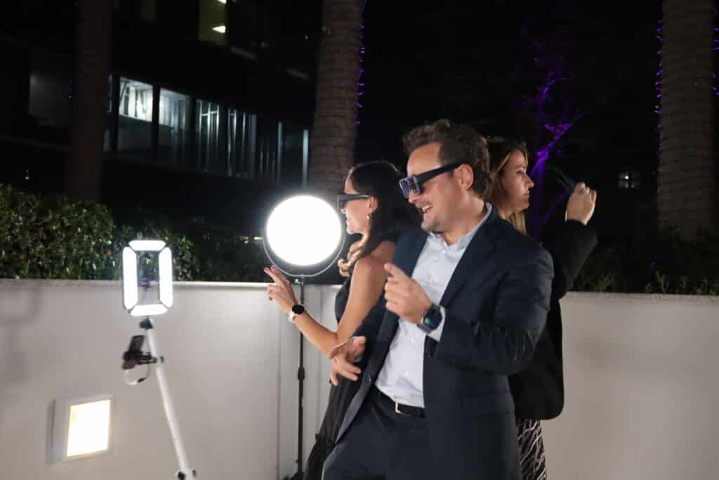 Guests enjoying an interactive photo booth experience with vibrant lighting and digital displays at Art Basel Miami 2025 event.